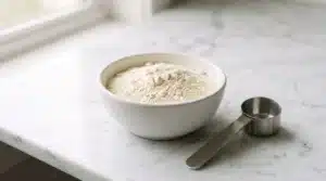 Beef protein isolate powder in a white bowl with a scoop, representing clean dairy‑free protein for muscle and joint health