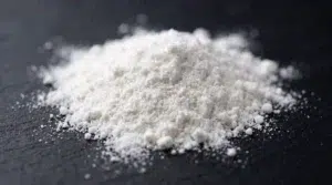 Macro view of white hydrolyzed collagen peptide powder for supplement formulation.