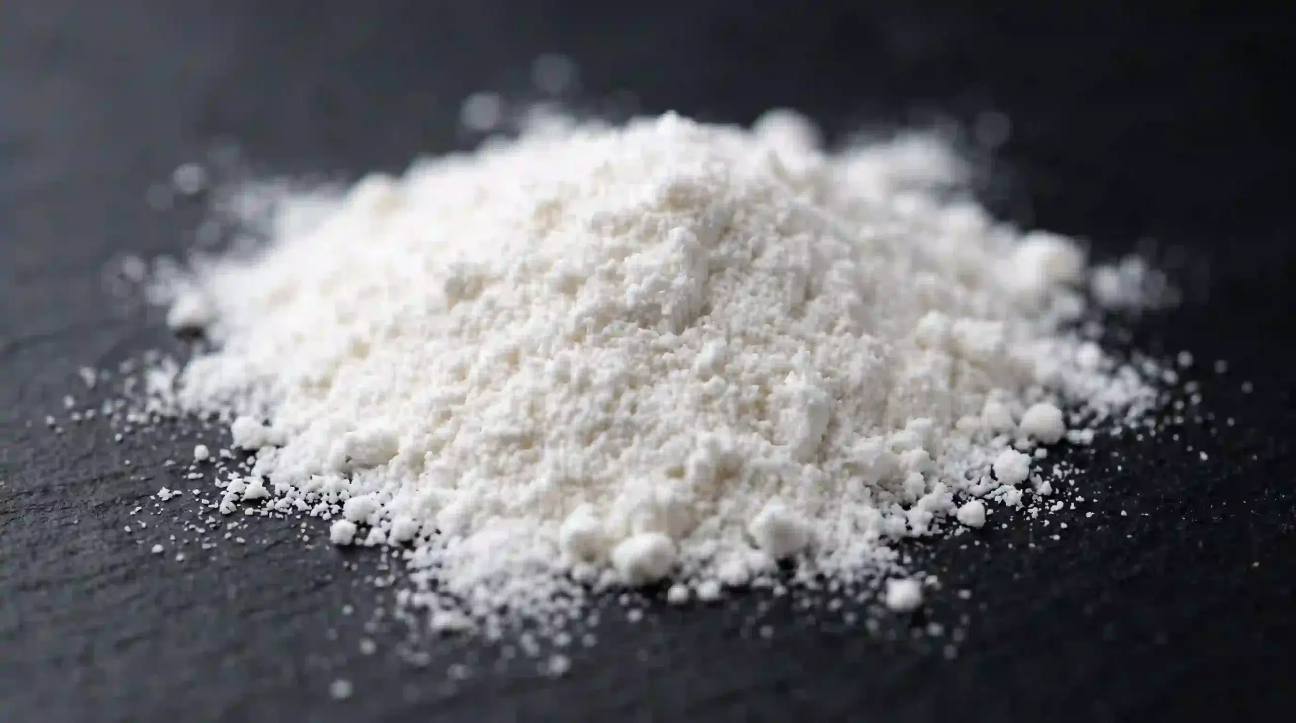 Macro view of white hydrolyzed collagen peptide powder for supplement formulation.